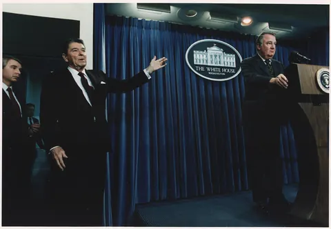 Photograph of President Reagan motioning to Ed Meese during a White House Press Briefing on Iran-Contra - NARA - 198579