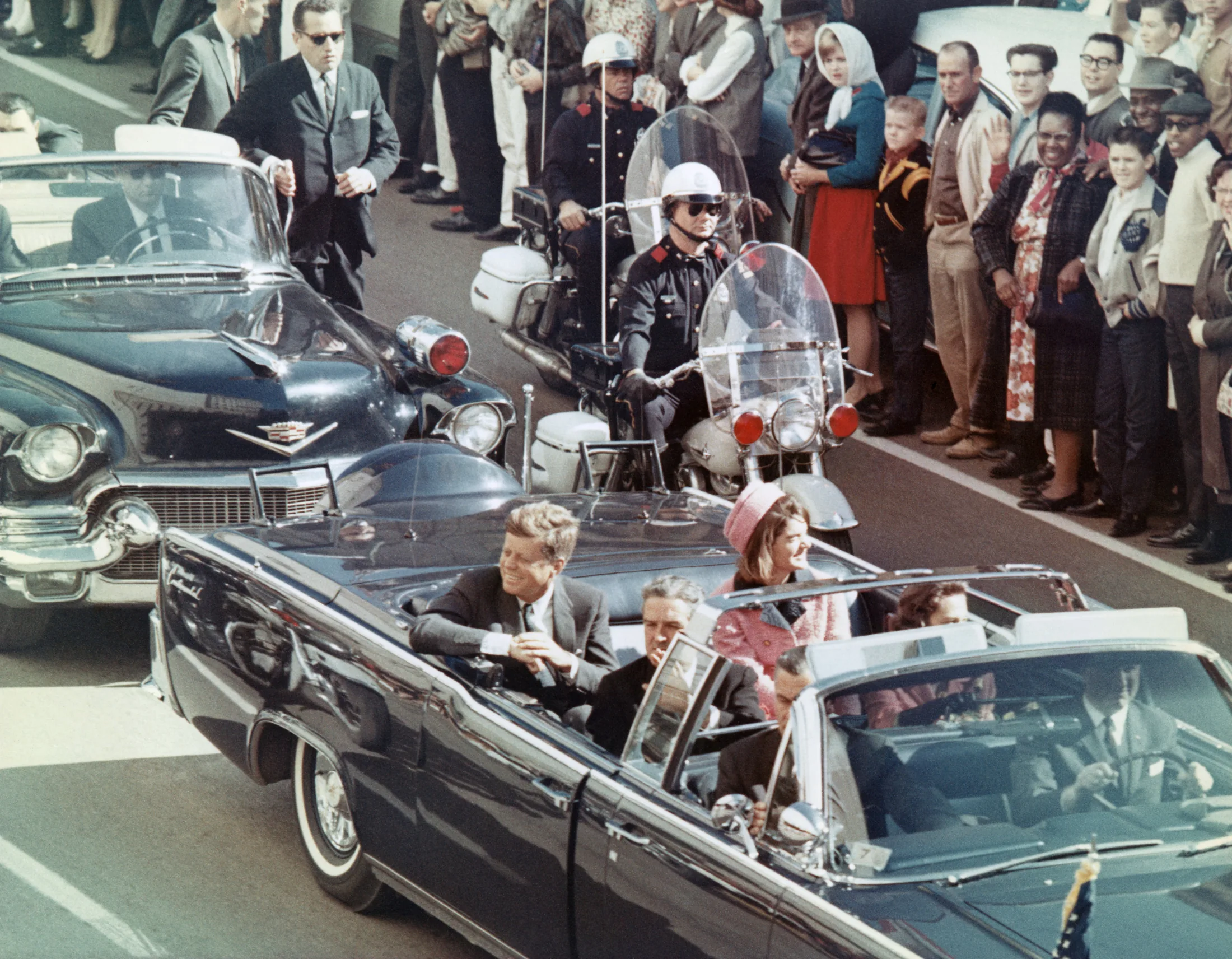 Picture of President Kennedy in the limousine in Dallas, Texas, on Main Street, minutes before the assassination. Also in the presidential limousine are Jackie Kennedy, Texas Governor John Connally, and his wife, Nellie.